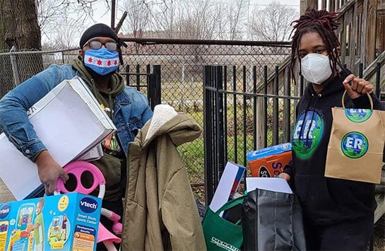 Alumnus Charles Pickett and his sister Mercedes Pickett holding holiday gifts