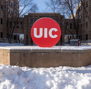 Snow covers the ground of campus buildings with a big, red 