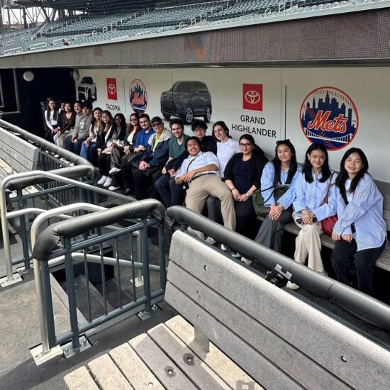 Students sitting in MLB Mets dugout, Management Leadership Association (MLA)