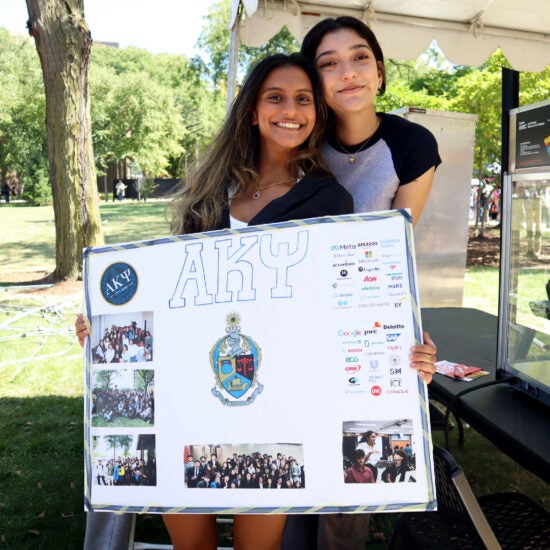 Student organization stand at UIC's Involvement Fair. Next to the stand is a sign that reads 'Developing Future Business Leaders in Chicago'.